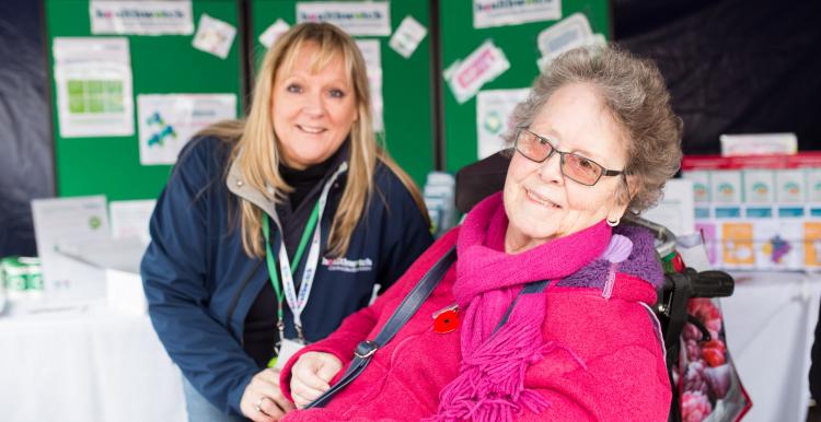 Elderly lady in a wheelchair with her carer