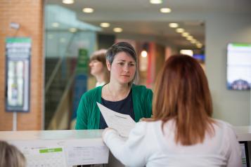 Woman talking to a receptionist 