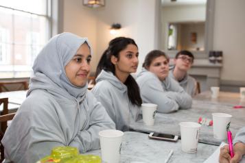 Young girls sitting at a row of desks