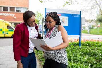 Two women talking outside a hospital